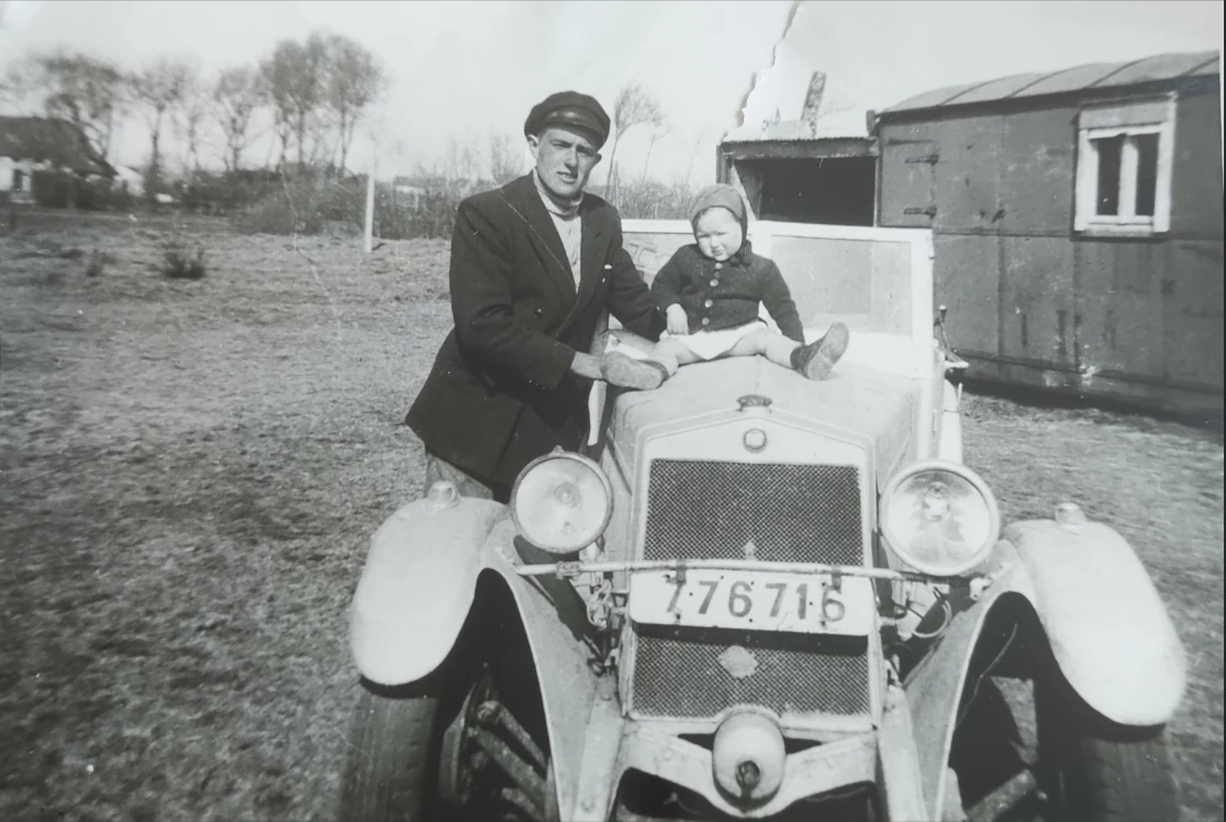 Aimé Deman avec un enfant non identifié devant une automobile ancienne